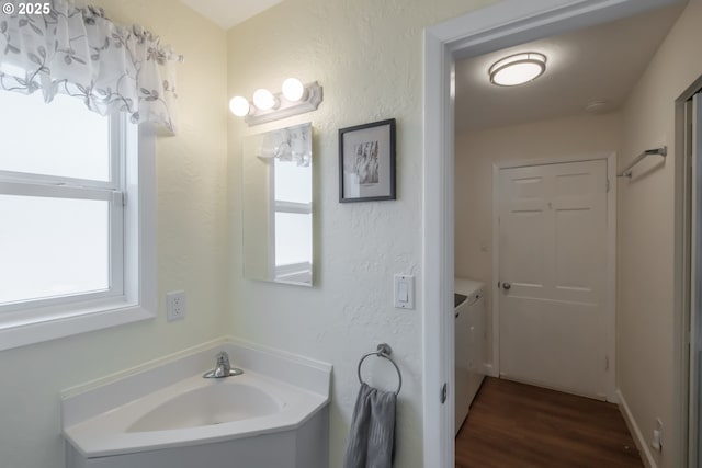 bathroom with a textured wall and wood finished floors