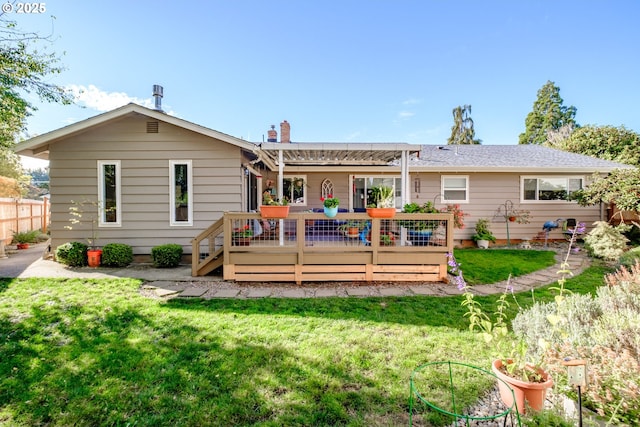 back of house featuring a deck, a lawn, and fence