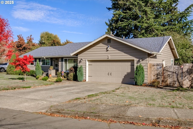 ranch-style home featuring driveway, an attached garage, and a shingled roof