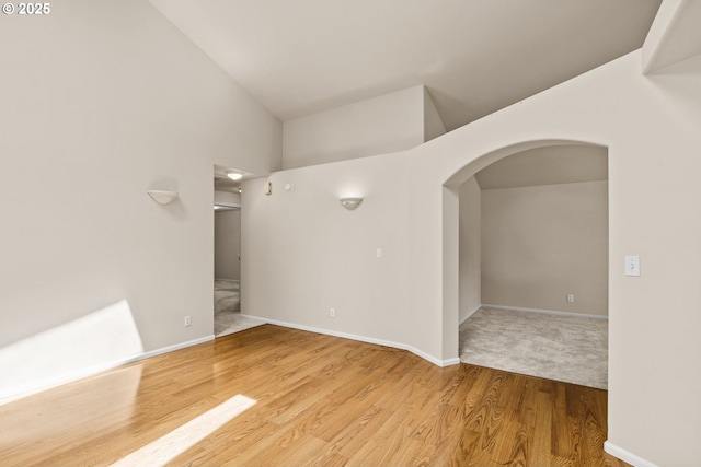 2494 Cubit St, Eugene, OR 97402 - unfurnished room with arched walkways, wood finished floors, baseboards, and lofted ceiling