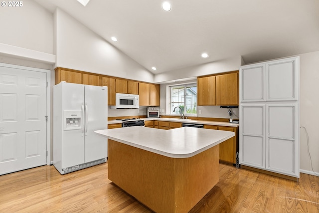 2494 Cubit St, Eugene, OR 97402 - kitchen with white appliances, light wood-type flooring, light countertops, recessed lighting, and a kitchen island