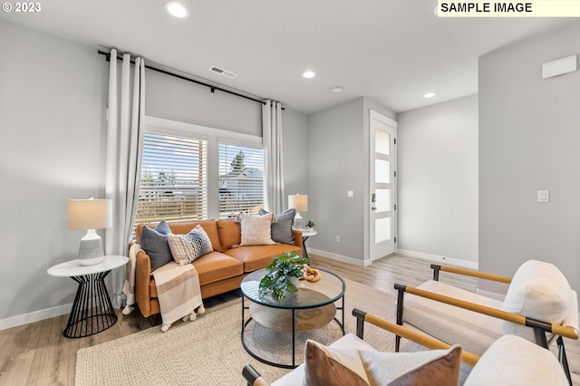 living area featuring light wood-style flooring, recessed lighting, and baseboards