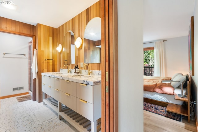 bathroom featuring visible vents, vanity, ensuite bathroom, wooden walls, and a stall shower
