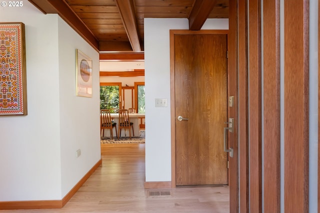 hall with visible vents, beamed ceiling, light wood-style floors, baseboards, and wood ceiling