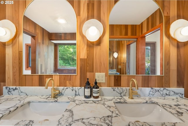 full bath featuring vanity and wood walls