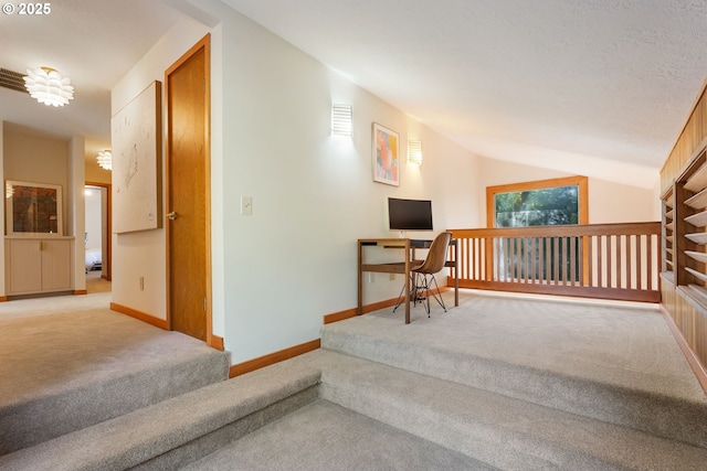 interior space with carpet floors, baseboards, and vaulted ceiling