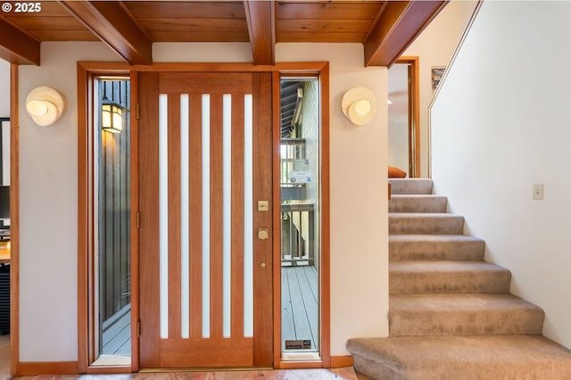entrance foyer with wooden ceiling, beamed ceiling, and stairs