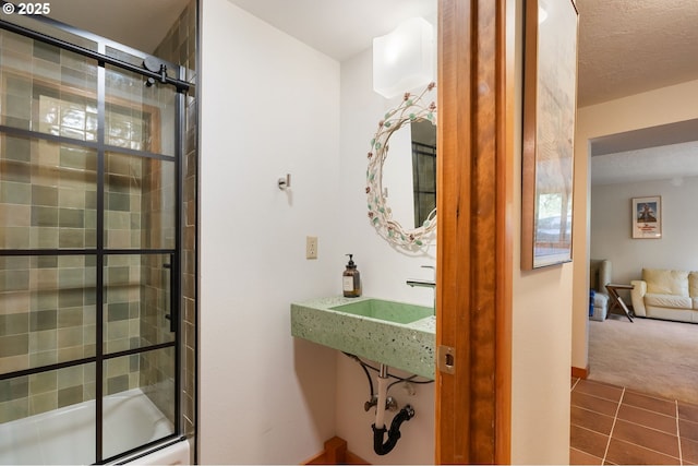 bathroom with a sink, tile patterned floors, and tiled shower