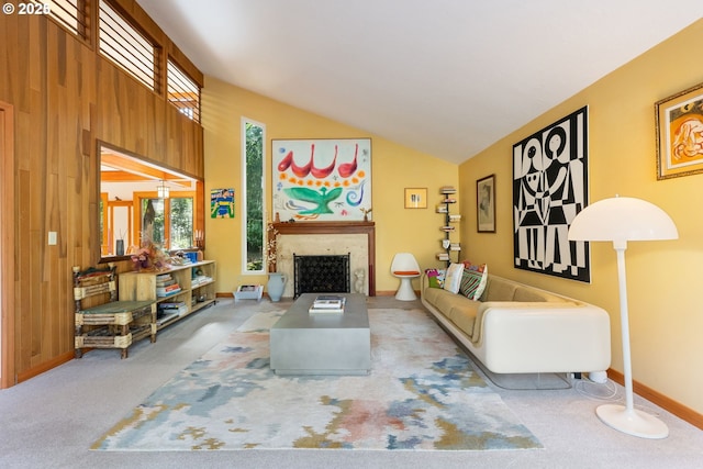 carpeted living area featuring baseboards, vaulted ceiling, plenty of natural light, and a fireplace