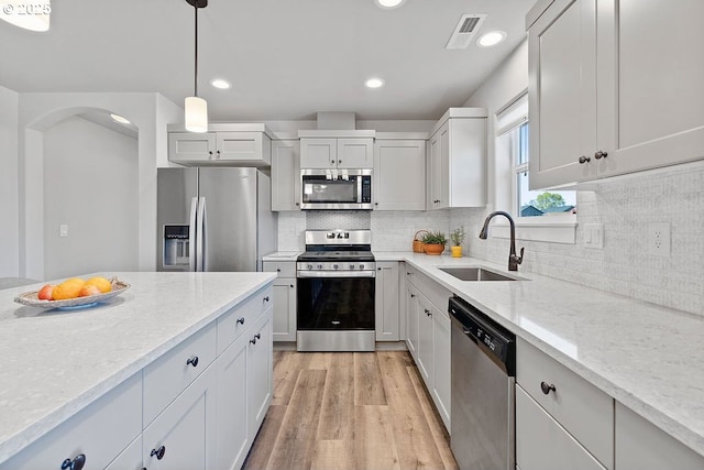 902 SE 3rd St, Prineville, OR 97754 - kitchen featuring light wood finished floors, light stone countertops, a sink, visible vents, and appliances with stainless steel finishes