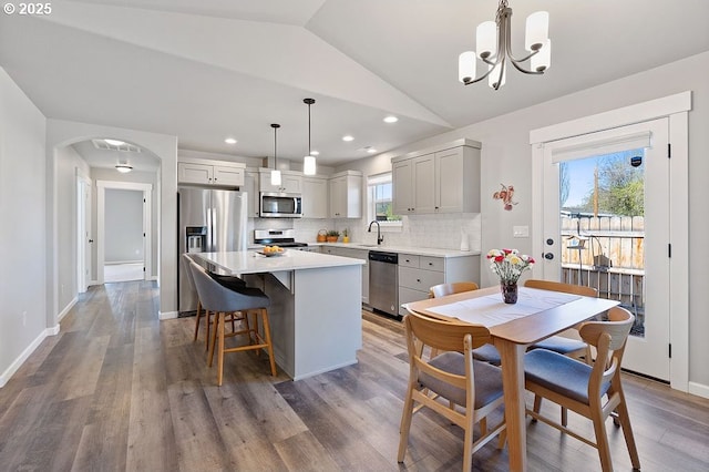 902 SE 3rd St, Prineville, OR 97754 - kitchen featuring appliances with stainless steel finishes, a kitchen island, a sink, a notable chandelier, and lofted ceiling