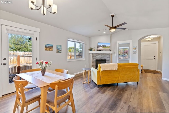 902 SE 3rd St, Prineville, OR 97754 - dining area featuring a healthy amount of sunlight, ceiling fan with notable chandelier, a stone fireplace, and lofted ceiling