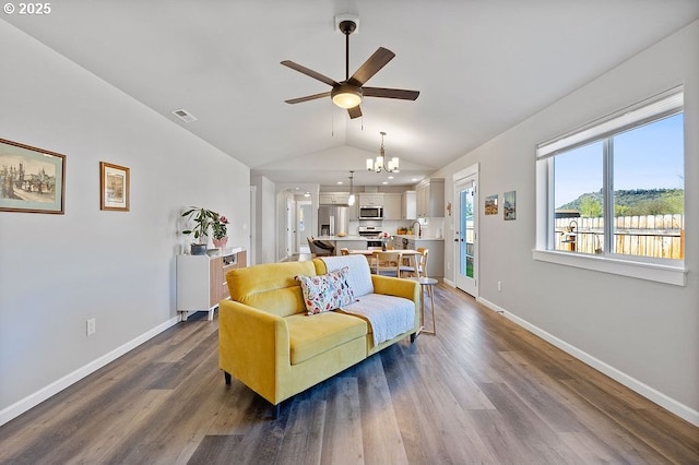902 SE 3rd St, Prineville, OR 97754 - living room featuring dark wood-style flooring, baseboards, lofted ceiling, and ceiling fan with notable chandelier