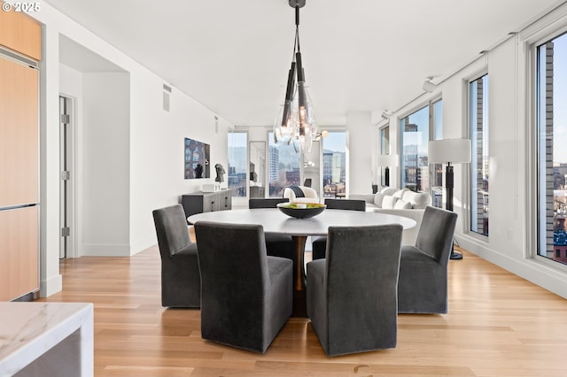 dining space featuring light hardwood / wood-style floors and a notable chandelier