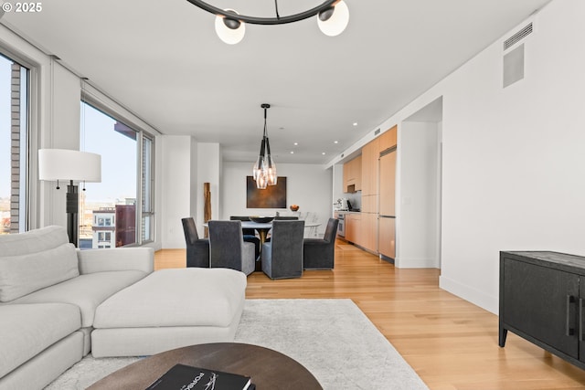 living room featuring an inviting chandelier and light hardwood / wood-style flooring