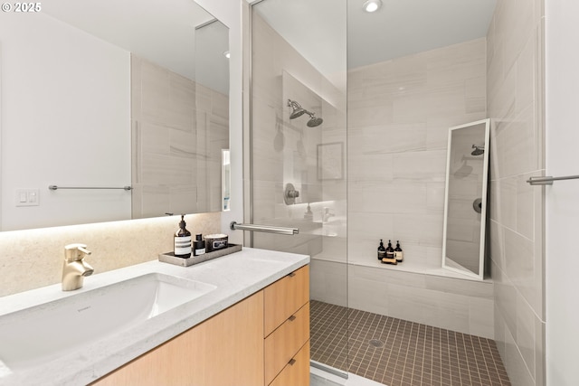 bathroom featuring tiled shower and vanity