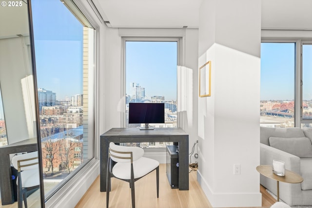 home office with light hardwood / wood-style flooring