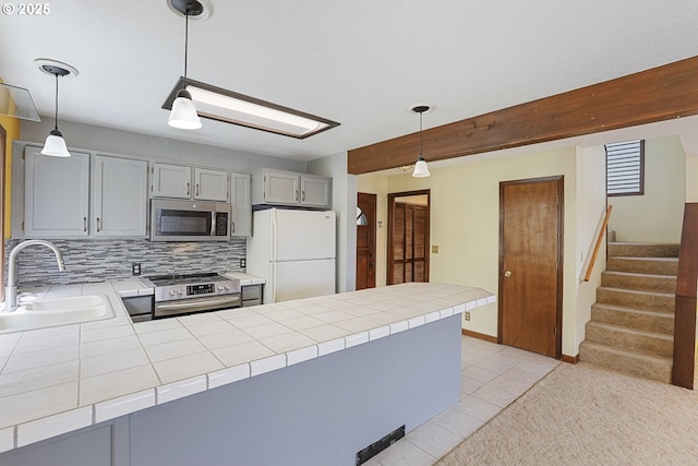 26400 NW St Helens Rd Unit 57, Scappoose, OR 97056 - kitchen featuring stainless steel appliances, a sink, a peninsula, tile countertops, and tasteful backsplash