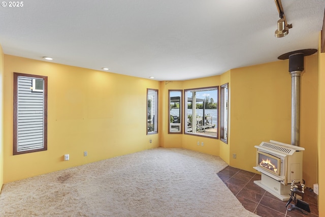 26400 NW St Helens Rd Unit 57, Scappoose, OR 97056 - unfurnished living room with a wood stove, recessed lighting, carpet flooring, and a water view