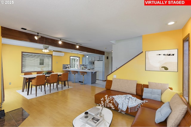 26400 NW St Helens Rd Unit 57, Scappoose, OR 97056 - living area featuring track lighting, light wood finished floors, a wall mounted AC, and ceiling fan