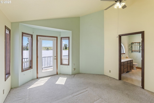 26400 NW St Helens Rd Unit 57, Scappoose, OR 97056 - interior space featuring light carpet, vaulted ceiling, a water view, and a ceiling fan