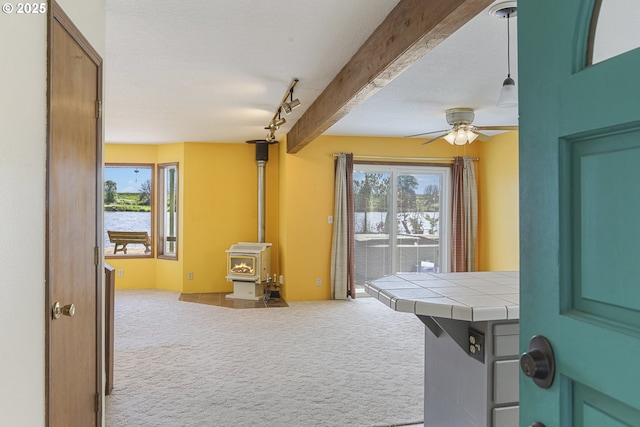 26400 NW St Helens Rd Unit 57, Scappoose, OR 97056 - playroom with carpet flooring, a water view, a wood stove, and healthy amount of natural light
