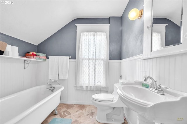 8014 N Johnswood Dr, Portland, OR 97203 - full bathroom featuring vaulted ceiling, a freestanding tub, toilet, wainscoting, and a sink