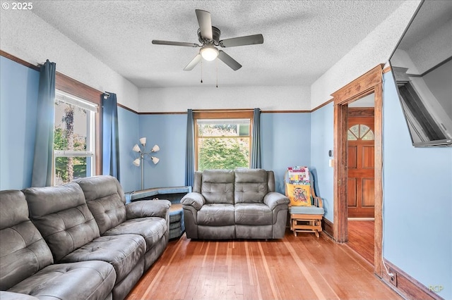 8014 N Johnswood Dr, Portland, OR 97203 - living area featuring light wood finished floors, plenty of natural light, a ceiling fan, and a textured ceiling