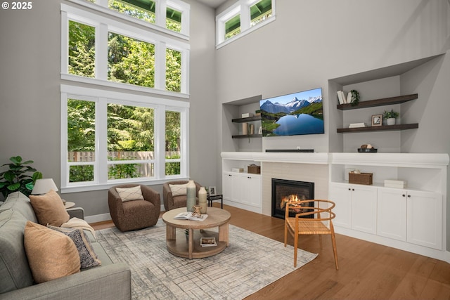 4720 Firwood Rd, Lake Oswego, OR 97035 - living area featuring a fireplace, a towering ceiling, and wood finished floors