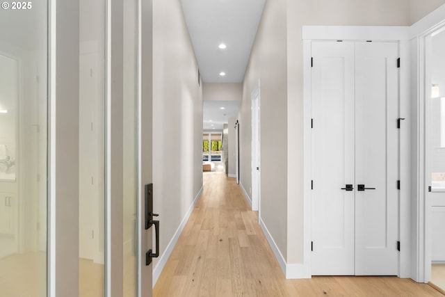 hall with baseboards, light wood-type flooring, and recessed lighting