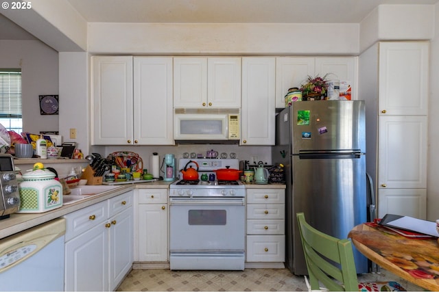 kitchen featuring sink, white cabinets, and white appliances