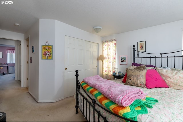 bedroom with light colored carpet, a closet, and a textured ceiling