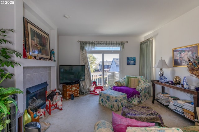 carpeted living room featuring a tile fireplace