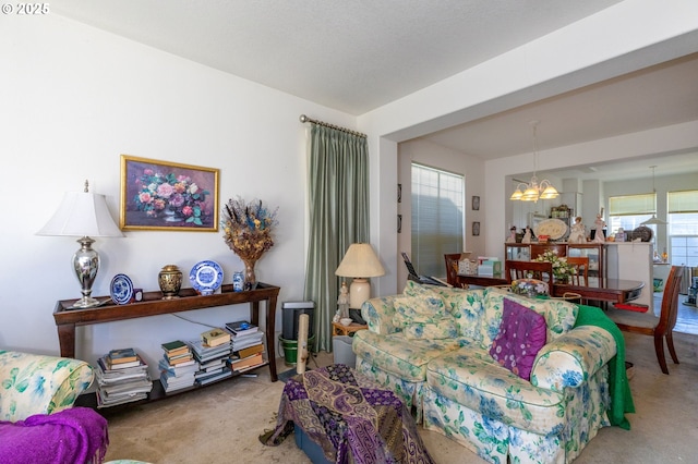 living room featuring an inviting chandelier and carpet floors