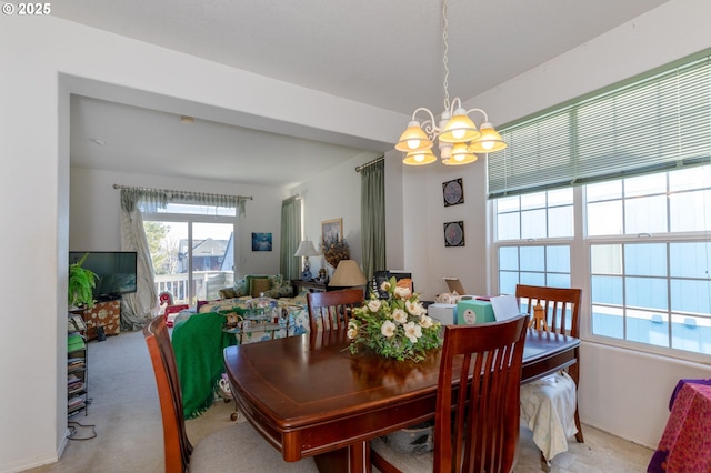 carpeted dining room featuring a chandelier