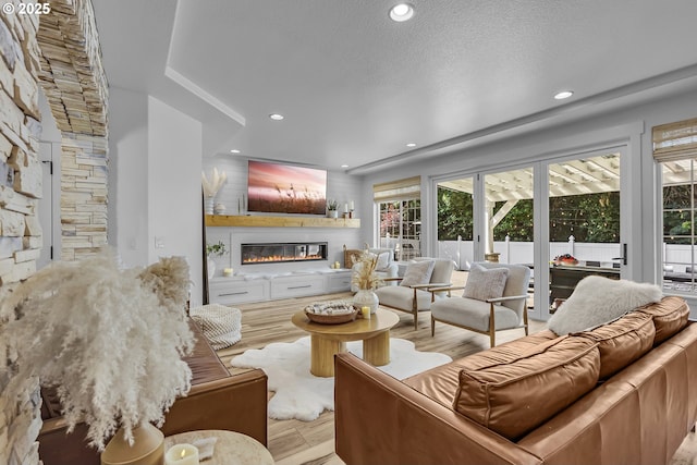 2646 N Lambert St, Cornelius, OR 97113 - living room featuring a glass covered fireplace, wood finished floors, recessed lighting, and a textured ceiling