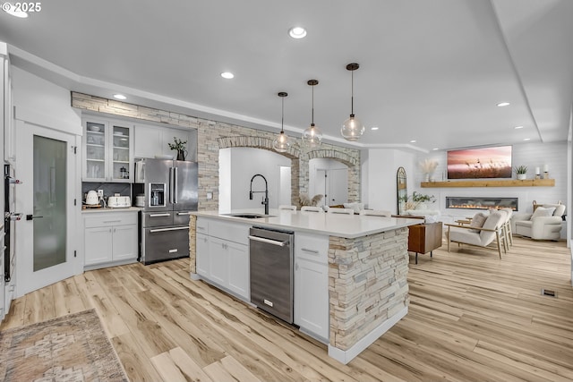 2646 N Lambert St, Cornelius, OR 97113 - kitchen with stainless steel appliances, arched walkways, light wood-style flooring, recessed lighting, and light countertops