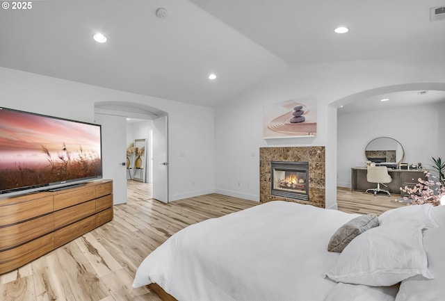 2646 N Lambert St, Cornelius, OR 97113 - bedroom featuring arched walkways, vaulted ceiling, wood finished floors, a fireplace, and recessed lighting