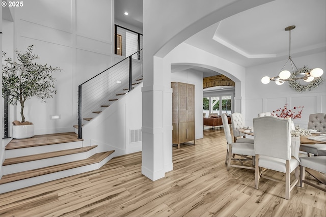 2646 N Lambert St, Cornelius, OR 97113 - dining area featuring a decorative wall, arched walkways, light wood-type flooring, stairway, and a chandelier
