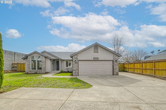 view of front facade with fence, an attached garage, stucco siding, concrete driveway, and a front lawn