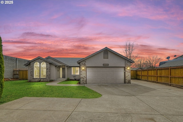 view of front of house with driveway, fence, a front yard, an attached garage, and brick siding