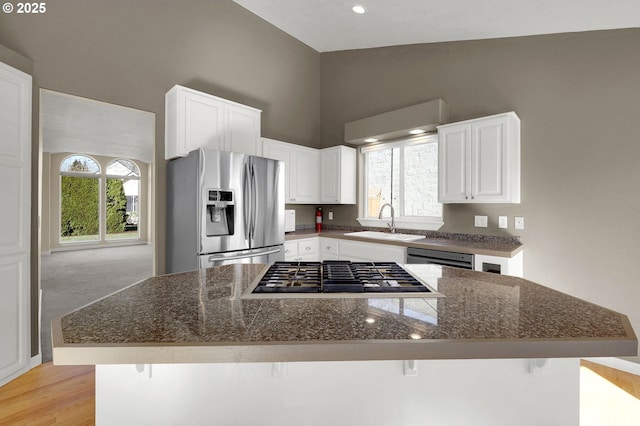 kitchen featuring a wealth of natural light, white cabinets, appliances with stainless steel finishes, and a sink