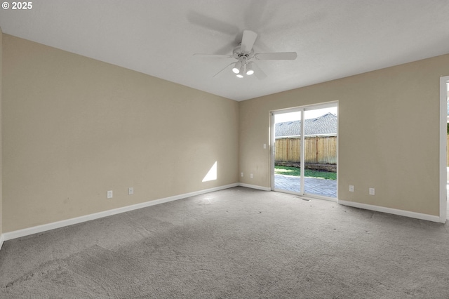 carpeted empty room featuring a ceiling fan and baseboards