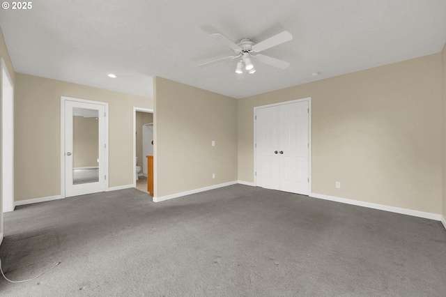 spare room with a ceiling fan, baseboards, and dark carpet
