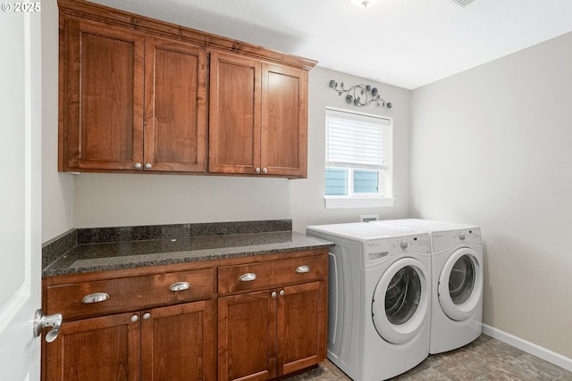 clothes washing area with cabinet space, washing machine and dryer, and baseboards
