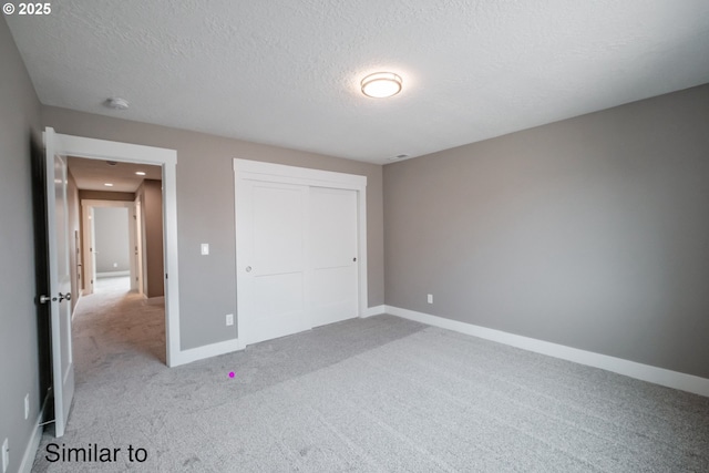342 NE Cedar St, Sublimity, OR 97385 - unfurnished bedroom with carpet flooring, a textured ceiling, baseboards, and a closet