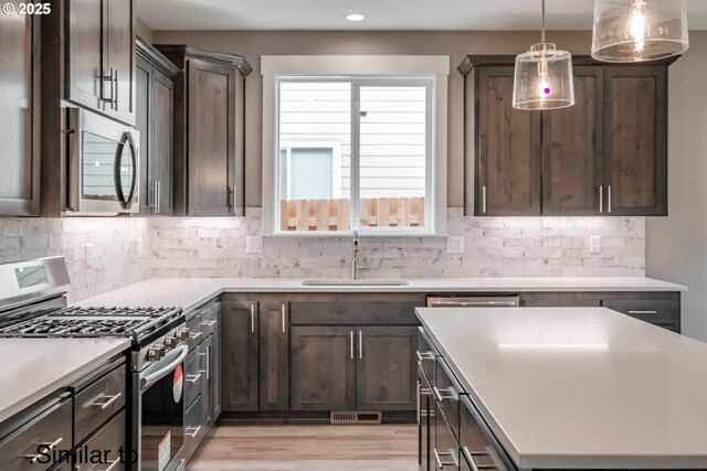 342 NE Cedar St, Sublimity, OR 97385 - kitchen with stainless steel appliances, a sink, light wood finished floors, dark brown cabinetry, and recessed lighting