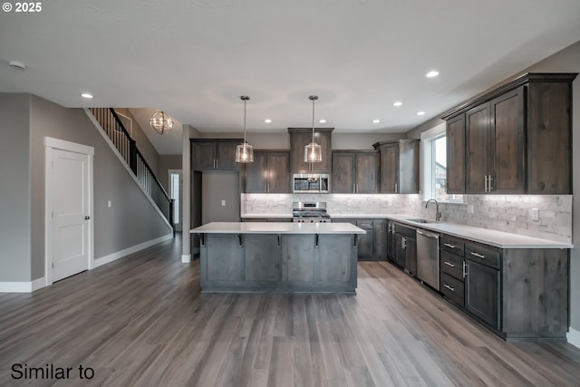 342 NE Cedar St, Sublimity, OR 97385 - kitchen featuring appliances with stainless steel finishes, a sink, backsplash, light wood-type flooring, and dark brown cabinets