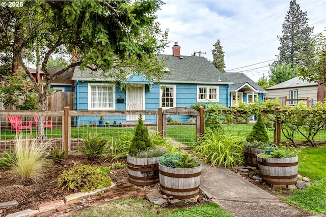 exterior space with a shingled roof, a chimney, and a fenced front yard