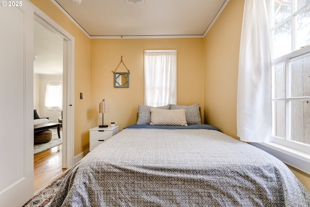 bedroom with visible vents, wood finished floors, and crown molding